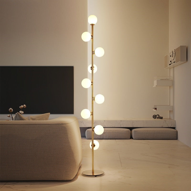 Lampadaire nordique minimaliste Magic Beans avec 9 boules en verre et structure dorée, parfait pour un éclairage élégant et contemporain dans les intérieurs modernes.

